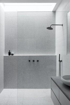 Open walk-in shower with natural stone and rain head