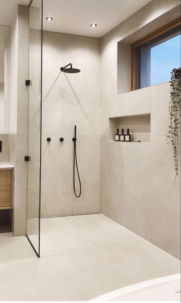 Stone-lined spa shower with rainfall head and accent lighting